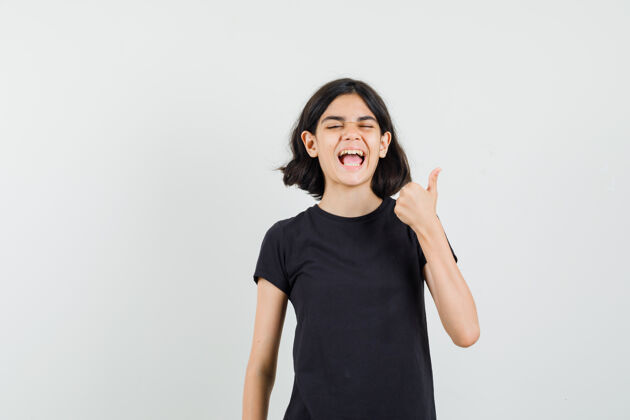 显示身穿黑色t恤的小女孩竖起大拇指 看上去很开心 正面照未成年人女孩