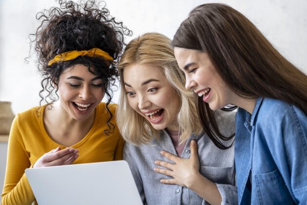 乐观使用笔记本电脑的快乐女人欢呼女性女人