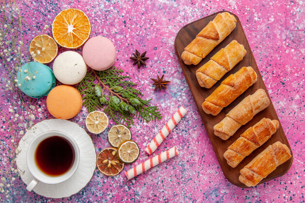 杯子顶视图：一杯茶 配上五颜六色的法国马卡龙和百吉饼 粉色墙壁蛋糕饼干糖甜饼茶饼干五颜六色马卡龙饼干