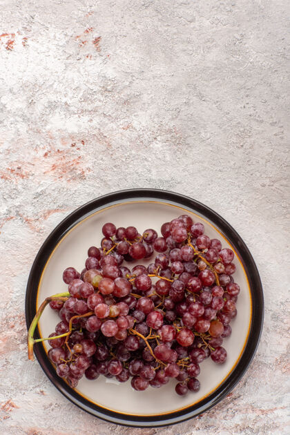 胡椒顶视图新鲜的红葡萄多汁和醇厚的水果盘内的白色表面浆果多汁盘子