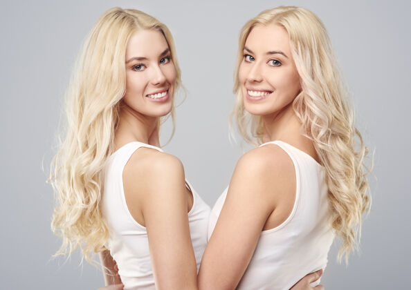 双人金发女孩双胞胎的后视图双胞胎成人转身