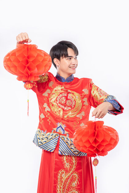 文化穿旗袍西服的男人在过年的时候到他店里装饰红灯红灯笼成人中国新年