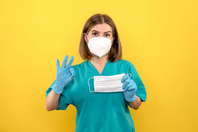 视图黄色地板上戴着蓝色手套和面罩的女医生护士医疗医院人漂亮面具
