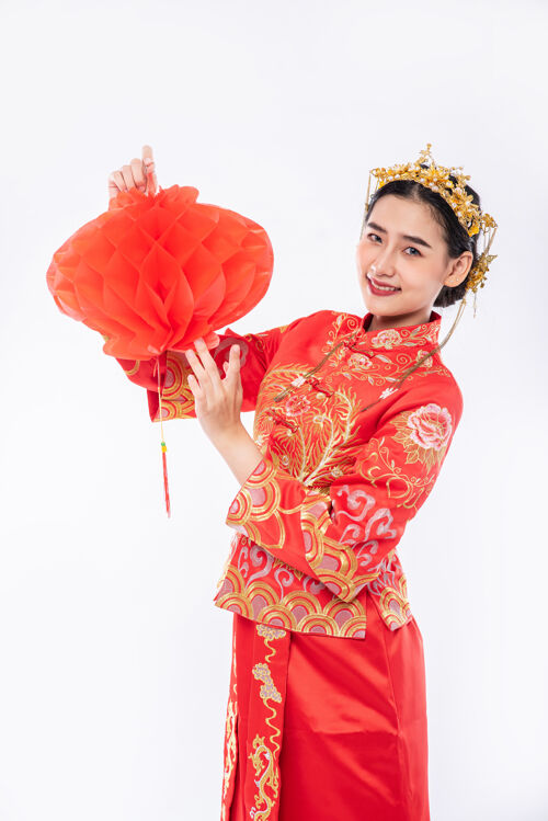 微笑穿旗袍套装的女士在春节向客户推销红灯旗袍传统服装红灯笼