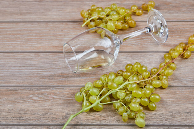 食物一堆葡萄和酒杯放在木头表面桌子水果玻璃