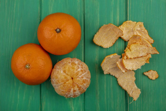 五颜六色绿色背景上带去皮橙子的俯视图橙色顶部景观