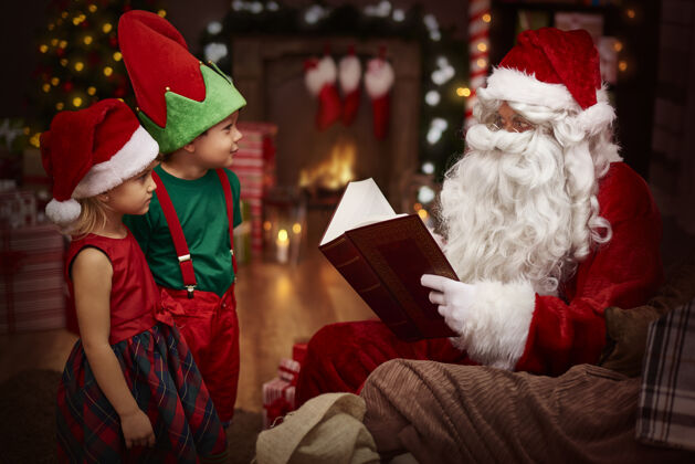 童年神秘的圣诞老人和孩子们一起看书聆听装饰品孩子