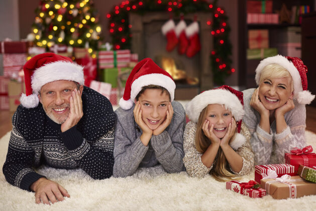 手放在头上客厅里欢乐家庭的画像圣诞装饰地毯圣诞帽