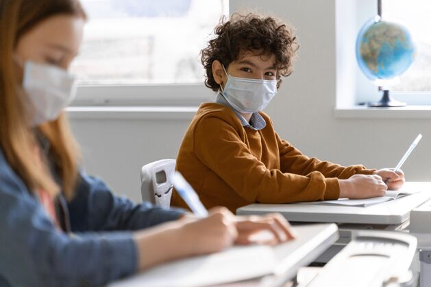 孩子孩子们戴着医用口罩侧视课堂学习冠状病毒新常态面罩