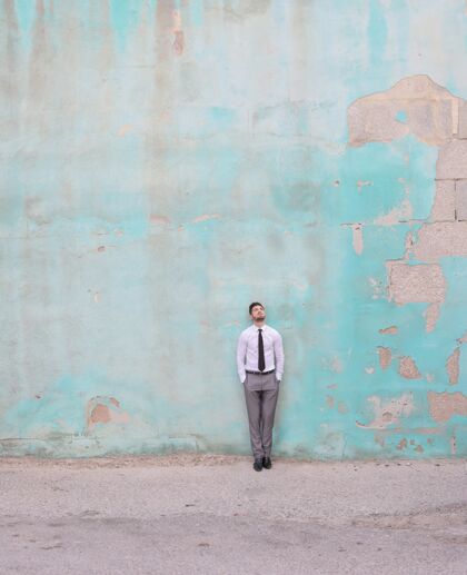 灰色一个穿衬衫打领带的白人男性站在绿色墙前的垂直镜头白色成人男士