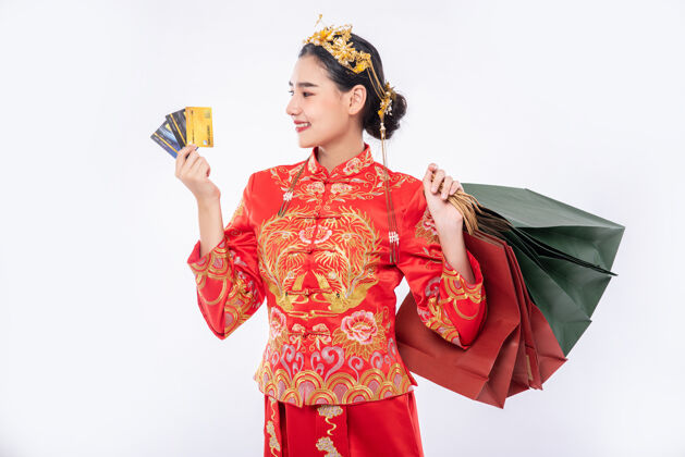 面具女人穿旗袍套装用信用卡在中国新年购物多家商店信用卡传统服装购买