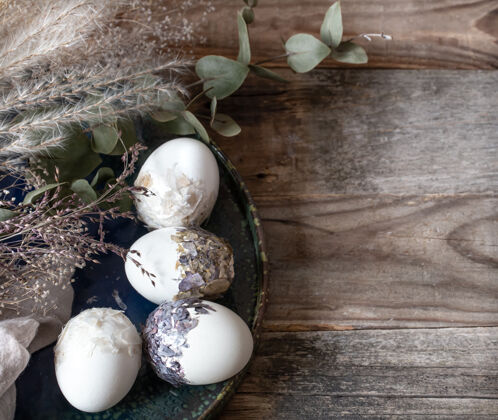 干花复活节彩蛋与装饰彩蛋在木制表面复制空间复活节彩蛋构图节日