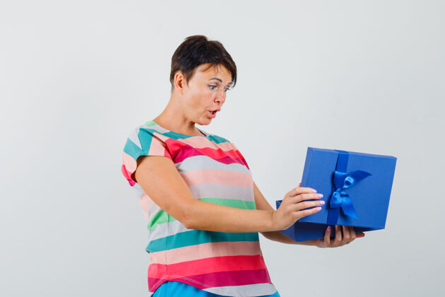 女性一个穿着条纹t恤的女人看着礼物盒 看起来很惊讶礼物笑乐趣