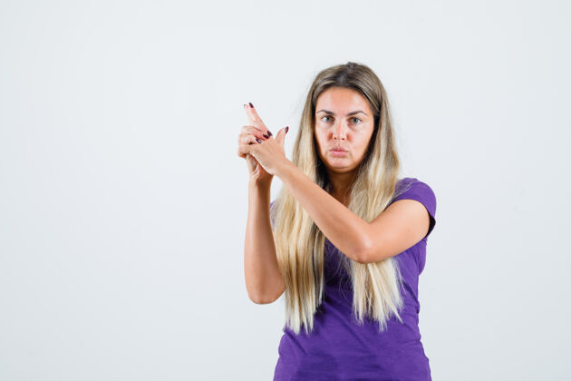 肖像一位金发女士穿着紫色t恤展示持枪姿势 看上去很自信 正面视图女人金发可爱