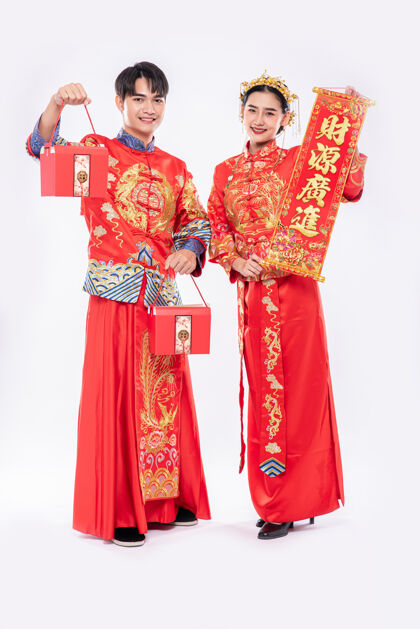 旗袍男男女女身穿旗袍站着 手持问候牌 背着红包尊重微笑中国新年