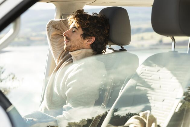 冒险侧视图的男子放松在车里 而在公路旅行旅行自然水平