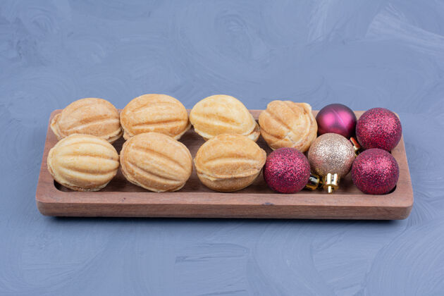 节日传统的胡桃饼干放在木制盘子里 还有圣诞装饰餐厅球精致