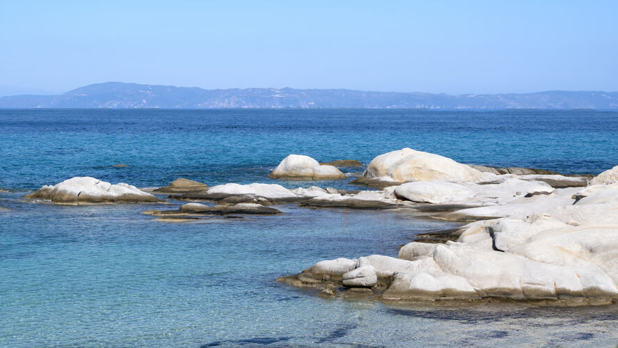 海滩爱琴海沿岸有岩石 水面和陆地 蓝色的海水 希腊山海湾沙