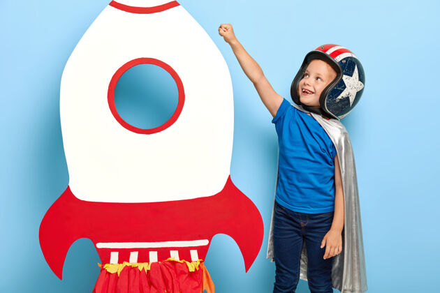 天文学快乐的孩子举起手臂靠近纸箱玩具火箭 想飞上太空服装宇航员装备