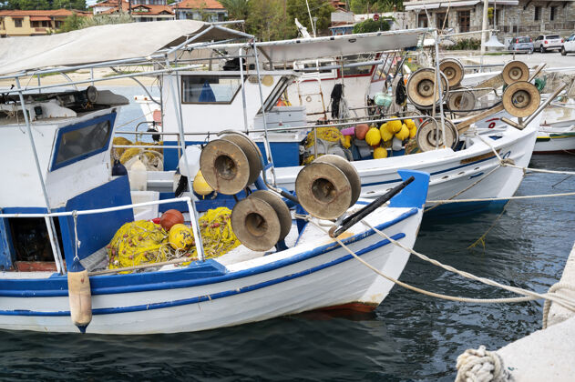 顶部停泊在港口 爱琴海在奥莫斯帕纳吉亚斯 希腊与许多渔业配件船船舶旧的颜色