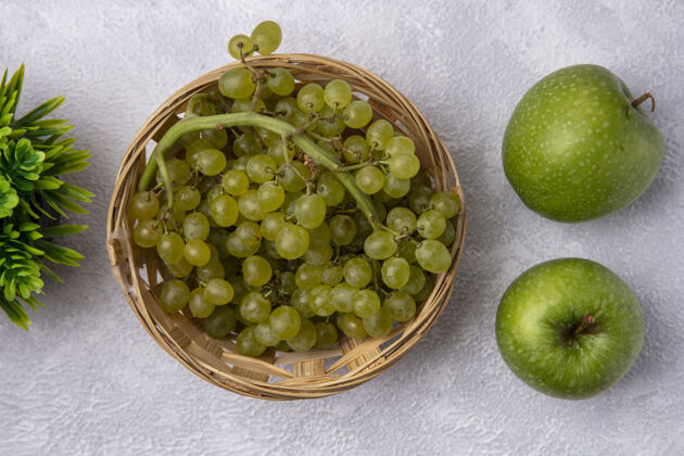 藤蔓顶视图绿色的葡萄在一个篮子里 绿色的苹果在白色的背景上景观葡萄顶部