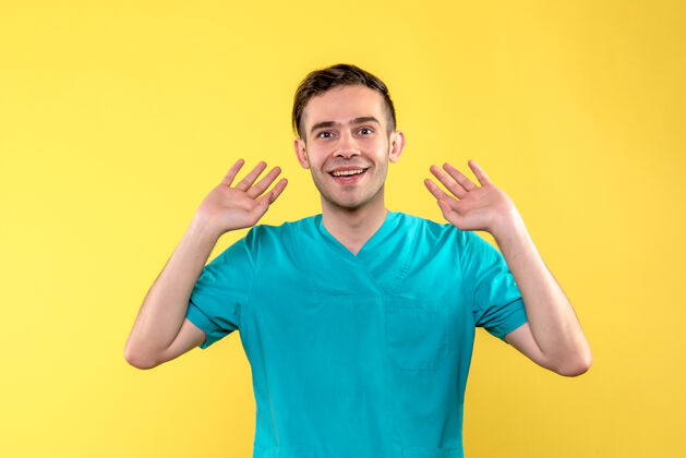 衬衫黄色墙上微笑的男医生的正面图微笑人成人