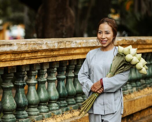 崇拜微笑的女人在庙里捧着花束有神论宗教信仰