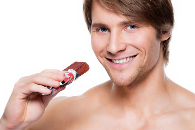 巧克力带着巧克力棒的英俊微笑的男人的肖像-孤立在白色上长牙成年长条