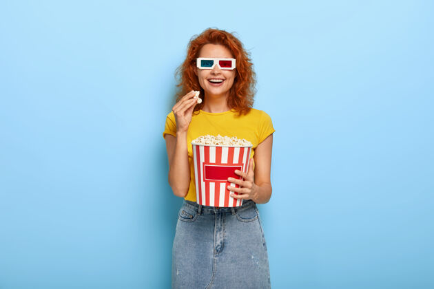 乐观电影节和自由时间的概念年轻乐观的红发快乐的女人一边看有趣的电影一边玩眼镜表情正面