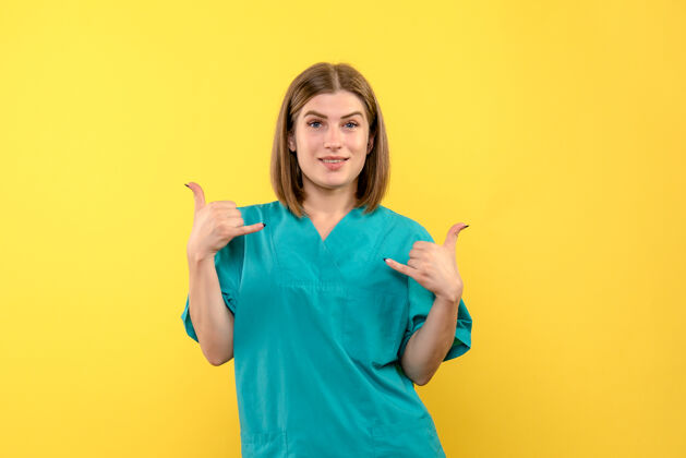 球衣黄墙上女医生笑脸的正面图黄色成人护士