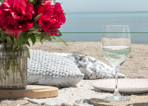 夏天带着鲜花和香槟的海边浪漫野餐度假的概念饮料沙子浪漫