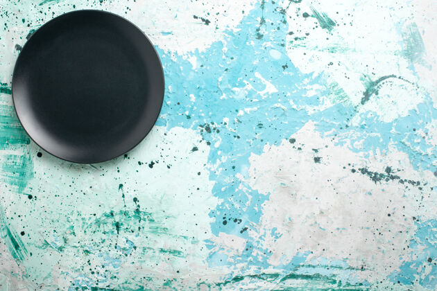 生俯视图蓝色桌子上的黑色圆形空盘子彩色盘子厨房餐具玻璃透明彩色盘