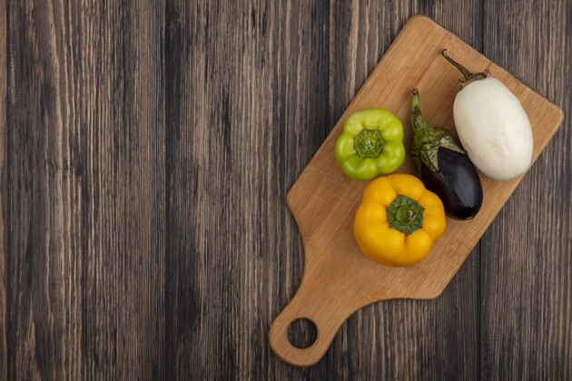白顶视图复制空间黑白茄子与彩色甜椒在砧板上木制背景视图茄子胡椒