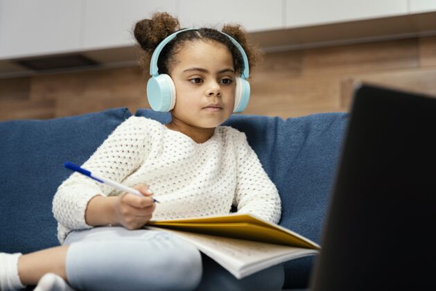 班级小女孩在网上上学时带着笔记本电脑和耳机女孩孩子课程