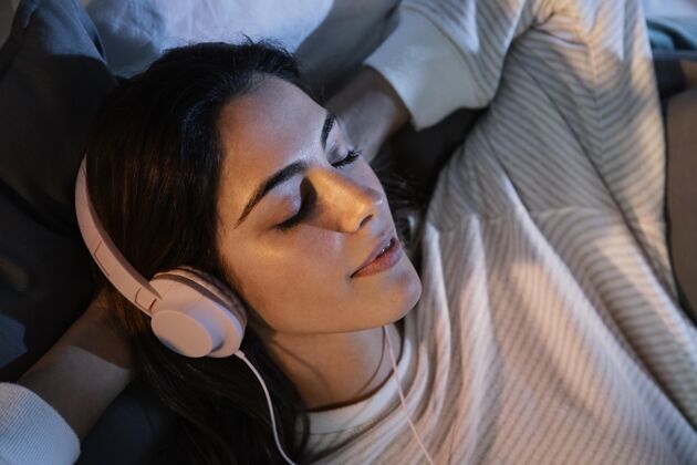 女人女人在家睡觉时用耳机听音乐室内假期女人
