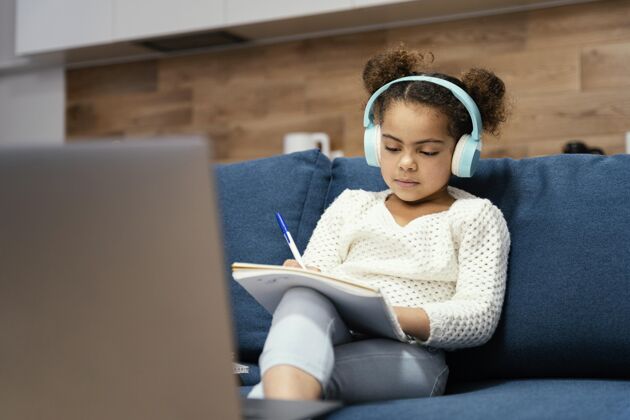 耳机小女孩在网上学校与笔记本电脑和耳机前视图女孩课程教育