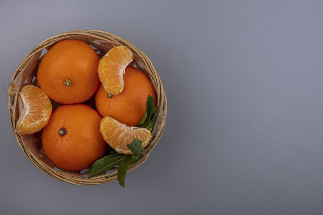 橙色顶视图复制空间橙色剥皮楔在一个篮子里的灰色背景楔形灰色果皮