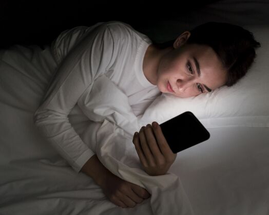科技女孩晚上在床上用手机科技年轻人上瘾