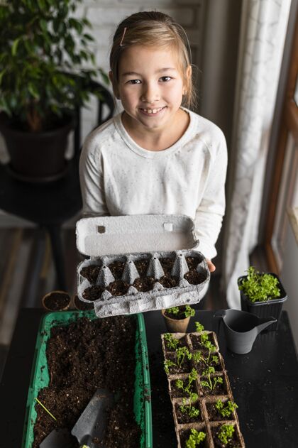 种植高角度的小女孩抱着种在鸡蛋盒里的种子农业栽培有机