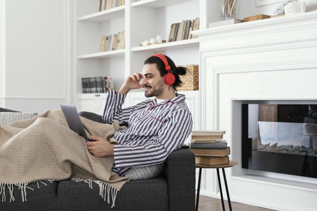 男性穿着睡衣的男人在用笔记本电脑活动无忧无虑科技
