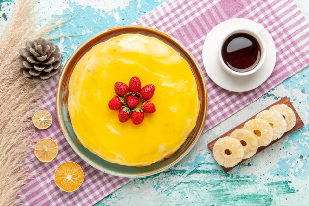 新鲜俯瞰美味的蛋糕 黄色糖浆和新鲜的红色草莓放在浅蓝色的桌子上 饼干蛋糕烤甜甜的糖派茶顶部烘焙糖浆