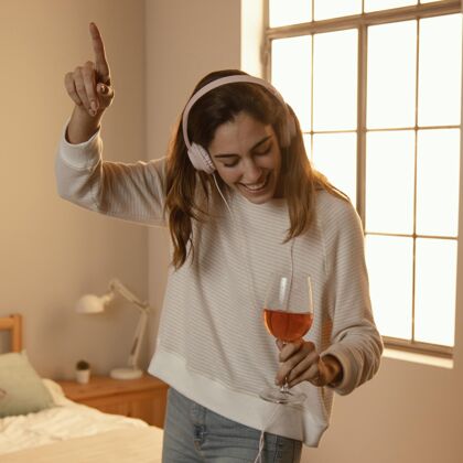 饮料女人在家里用耳机听音乐喝酒娱乐休假女人