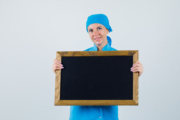 职员女医生拿着黑板 身着蓝色制服 看上去很乐观 正面照诊所制服护士