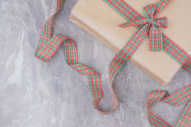 大理石大理石背景上有节日蝴蝶结的圣诞礼物圣诞弓装饰圣诞饰品
