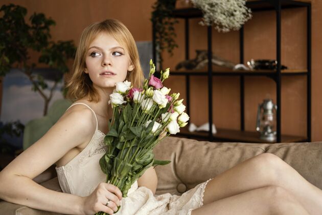 女性一个女人拿着一束美丽的春花在沙发上摆姿势春天花水平