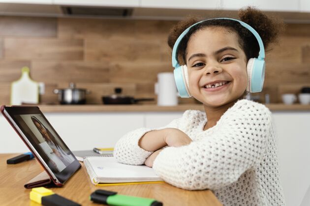 在线侧视图笑脸小女孩在网上学校与平板电脑和耳机班级知识课程