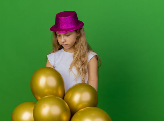 帽子戴着节日帽子的漂亮小女孩和一堆巴龙节日表情小