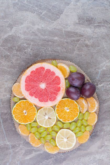 美味柑橘类水果 李子和葡萄放在木片上水果顶视图柚子
