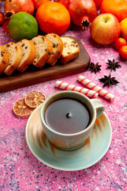 异国情调正面是美味的水果 粉红色的桌子上放着切片蛋糕和茶成分桌子早餐