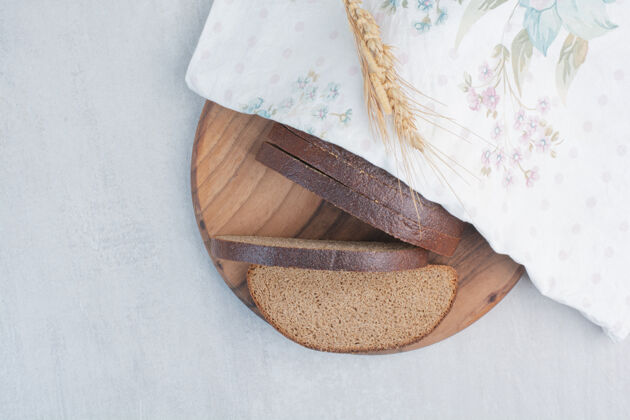 面包把新鲜的棕色面包片放在桌布上新鲜面包切片食品